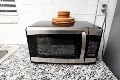 a microwave on a counter with a stack of cookies at Comfy Condos at Middle River Apt 3 in Fort Lauderdale