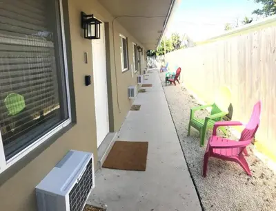 a row of chairs sitting on a sidewalk next to a building at Comfy Condos at Middle River Apt 3 in Fort Lauderdale