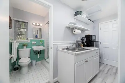 a white bathroom with a sink and a toilet at The Dolphin Studio at Lake Ridge in Fort Lauderdale