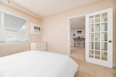 a white bedroom with a bed and a window at The Residences at Lake Ridge Apt 2 in Fort Lauderdale