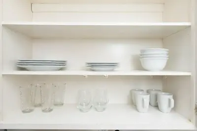 a white shelf with bowls and glasses and plates at The Residences at Lake Ridge Apt 3 in Fort Lauderdale