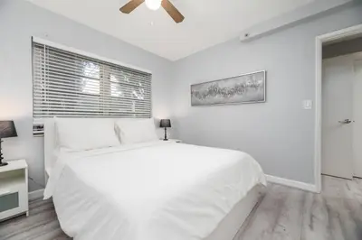 a white bedroom with a large bed and a window at The Residences at Lake Ridge Apt 3 in Fort Lauderdale