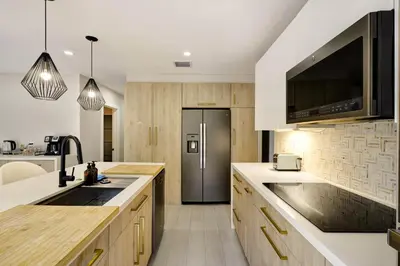 a kitchen with a sink and a refrigerator at Designer Home w Pool & Firepit - 7 min to Brickell in Miami