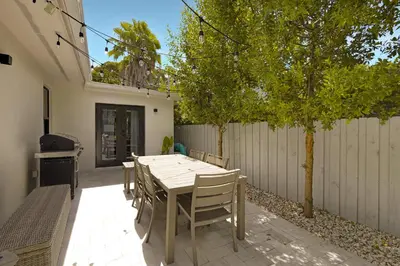 a patio with a table and chairs and a fence at Designer Home w Pool & Firepit - 7 min to Brickell in Miami