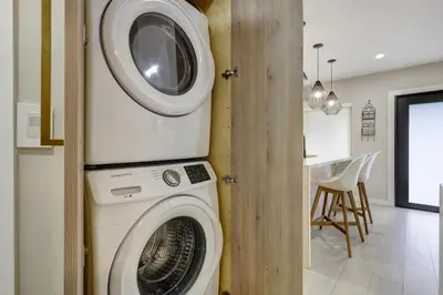 a washer and dryer in a room with a kitchen at Designer Home w Pool & Firepit - 7 min to Brickell in Miami