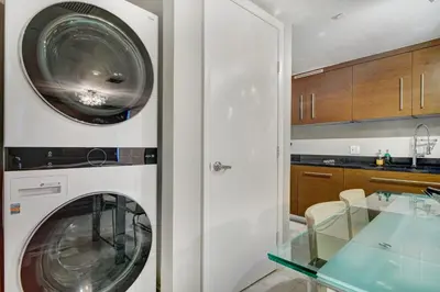 a washing machine in a kitchen with a glass table at Lux 2BR - Water View - Pool - Spa - FREE Parking in Miami