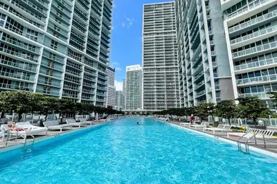 a large swimming pool in a city with tall buildings at Lux 2BR - Water View - Pool - Spa - FREE Parking in Miami