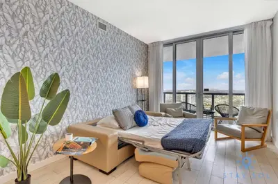 a living room with a bed and a couch at Amazing View - Pool - Gym - 2 Bedrooms in Hallandale Beach