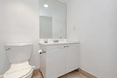 a white bathroom with a toilet and a sink at Hollywood on The Beach in Hollywood