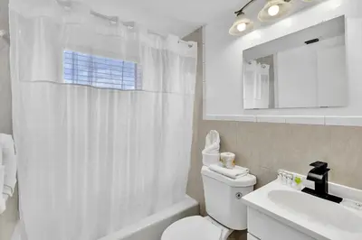 a white bathroom with a toilet and a sink at Coastal Sunset in Hollywood