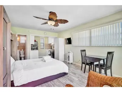 a bedroom with a bed and a table with chairs at Chic Studio Apartment in Hollywood Beach in Hollywood