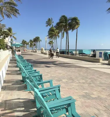 a row of green benches next to the beach at Chic Studio Apartment in Hollywood Beach in Hollywood