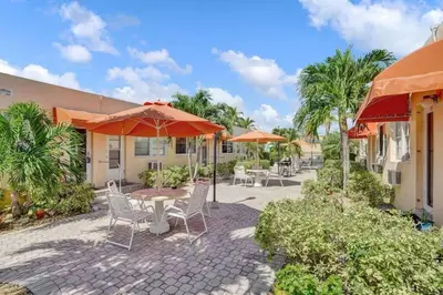 a patio with a table and chairs and umbrellas at Chic Studio Apartment in Hollywood Beach in Hollywood