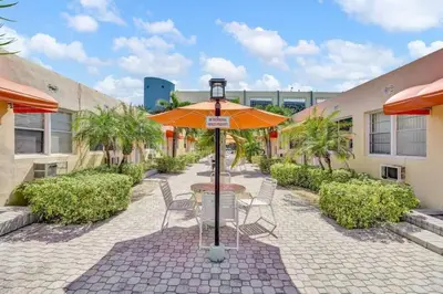 a patio with a table and chairs and an umbrella at Chic Studio Apartment in Hollywood Beach in Hollywood