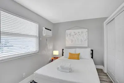 a white bedroom with a bed and a window at Rustic Retreats Beachy 1BR for 4 guests in the heart of Fort Lauderdale in Fort Lauderdale
