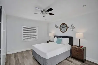 a white bedroom with a bed and a ceiling fan at Beach Isles Modern 1BR Apartment in Fort Lauderdale in Fort Lauderdale