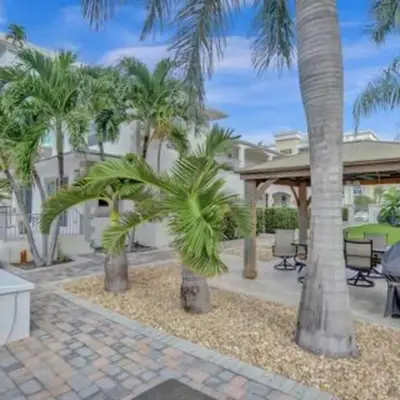 a house with palm trees and a patio at Beach Isles Modern Studio Apartment in Fort Lauderdale in Fort Lauderdale