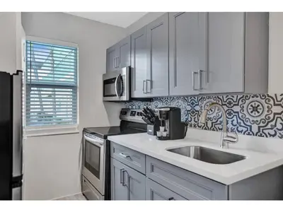 a white kitchen with a sink and a stove at Rustic Retreats Beachy 1BR for 4 guests in the heart of Fort Lauderdale in Fort Lauderdale