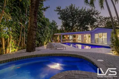 a swimming pool in front of a house at Cascada-Luxe Resort Heated Pool HotTub Wlk 2 Beach in Fort Lauderdale