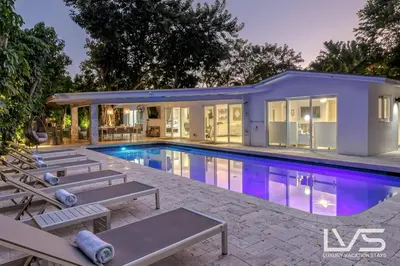 a swimming pool in front of a house at Cascada-Luxe Resort Heated Pool HotTub Wlk 2 Beach in Fort Lauderdale