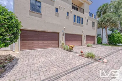 a large house with a garage in front of it at LVS Villa Alba- Walk2LasOlas, HeatedPool, RoofTopTerrace in Fort Lauderdale