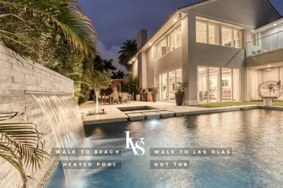 a swimming pool in front of a house at Poinciana-LuxeHome Wlk2Beach HeatedPool HotTub in Fort Lauderdale
