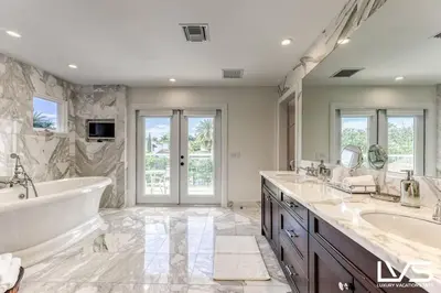 a bathroom with two sinks and a tub at Poinciana-LuxeHome Wlk2Beach HeatedPool HotTub in Fort Lauderdale