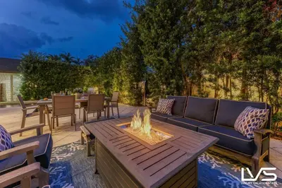 a patio with a couch and a fire pit at Poinciana-LuxeHome Wlk2Beach HeatedPool HotTub in Fort Lauderdale