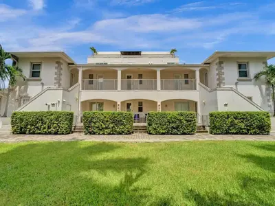 a large white house with a large yard at Beach Isles Modern 1BR in Fort Lauderdale with Patio in Fort Lauderdale