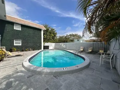 a large swimming pool in a yard with a house at Rustic Retreats Cozy 1BR for 4 guests minutes from Las Olas in Fort Lauderdale