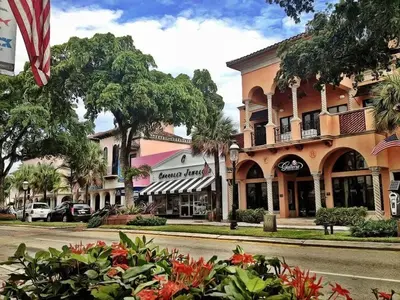 a street in front of a building with trees and flowers at Rustic Retreats Cozy 1BR for 4 guests minutes from Las Olas in Fort Lauderdale