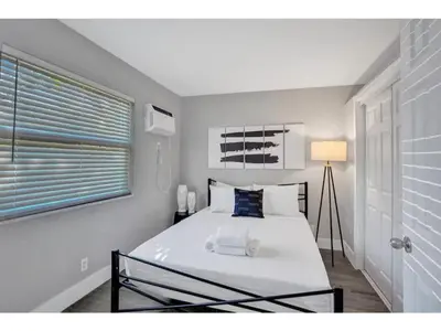 a bedroom with a large white bed with a window at Rustic Retreats Modern 1BR for 4 guests in the heart of Fort Lauderdale in Fort Lauderdale