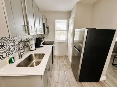 a kitchen with a sink and a refrigerator at Rustic Retreats Beachy 1BR for 4 guests in the heart of Fort Lauderdale in Fort Lauderdale