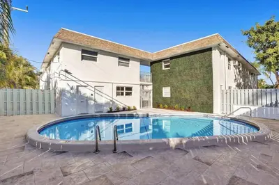 a swimming pool in front of a house at Rustic Retreats Cozy 1BR For 4 Guests In The Heart Of Fort Lauderdale in Fort Lauderdale