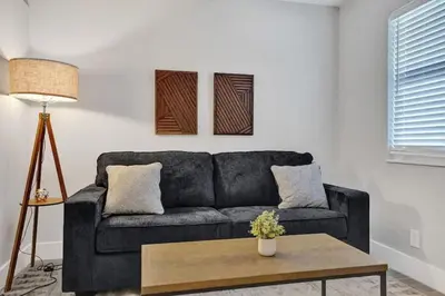 a living room with a black couch and a table at Rustic Retreats Beachy 1BR for 4 guests in the heart of Fort Lauderdale in Fort Lauderdale