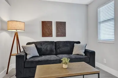 a living room with a black couch and a table at Rustic Retreats Cozy 1BR for 2 guests minutes from Las Olas in Fort Lauderdale