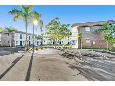 an empty parking lot with palm trees and a building at Rustic Retreats Beachy 1BR for 4 guests in the heart of Fort Lauderdale in Fort Lauderdale