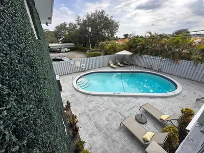 a swimming pool with chairs and a fence at Rustic Retreats Cozy 1BR for 4 guests minutes from Las Olas in Fort Lauderdale