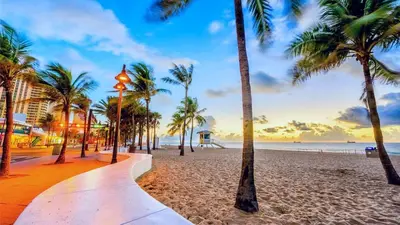 a beach with palm trees and the ocean at sunset at Rustic Retreats Cozy 1BR for 4 guests minutes from Las Olas in Fort Lauderdale