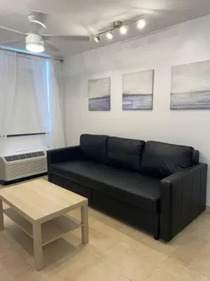a living room with a black couch and a table at South Beach Escape in Miami Beach