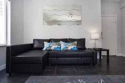 a black leather couch in a living room at Miami Beach Getaway 100 yards from Beach in Miami Beach