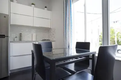 a dining room table with chairs and a kitchen at Miami Beach Getaway 100 yards from Beach in Miami Beach