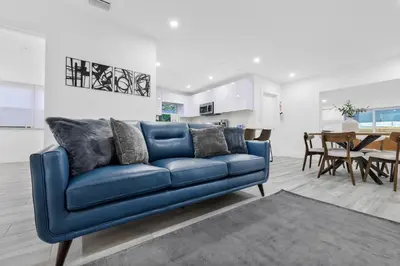 a blue couch in a living room with a dining room at Modern villa in Design District ! in Miami