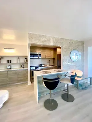 a kitchen with a counter and a table and chairs at Panoramic luxurious waterfront one bedroom apartment with Miami skyline view Free parking 5min drive to Miami Beach in Miami Beach