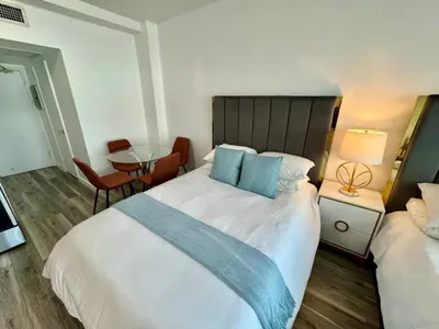 a hotel room with a large bed and a table at Directly on the Beach with Pool & Parking in Miami Beach