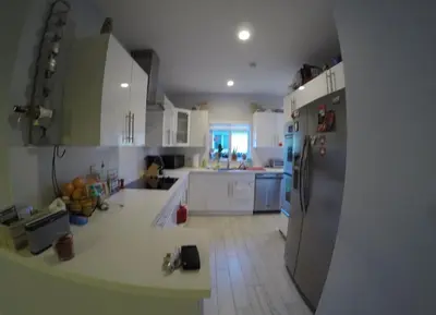 a kitchen with white cabinets and a refrigerator at Cozy room in a quiet home in Miami