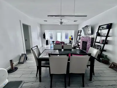 a dining room with a black table and chairs at Cozy room in a quiet home in Miami