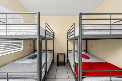 two bunk beds in a dorm room with a desk at Crocodhouse early check in eight years hosting in Fort Lauderdale