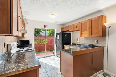 a kitchen with wooden cabinets and a counter top at Crocodhouse early check in eight years hosting in Fort Lauderdale