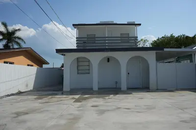 a small white building with a balcony on top of it at Charming two bedroom apartment. in Miami